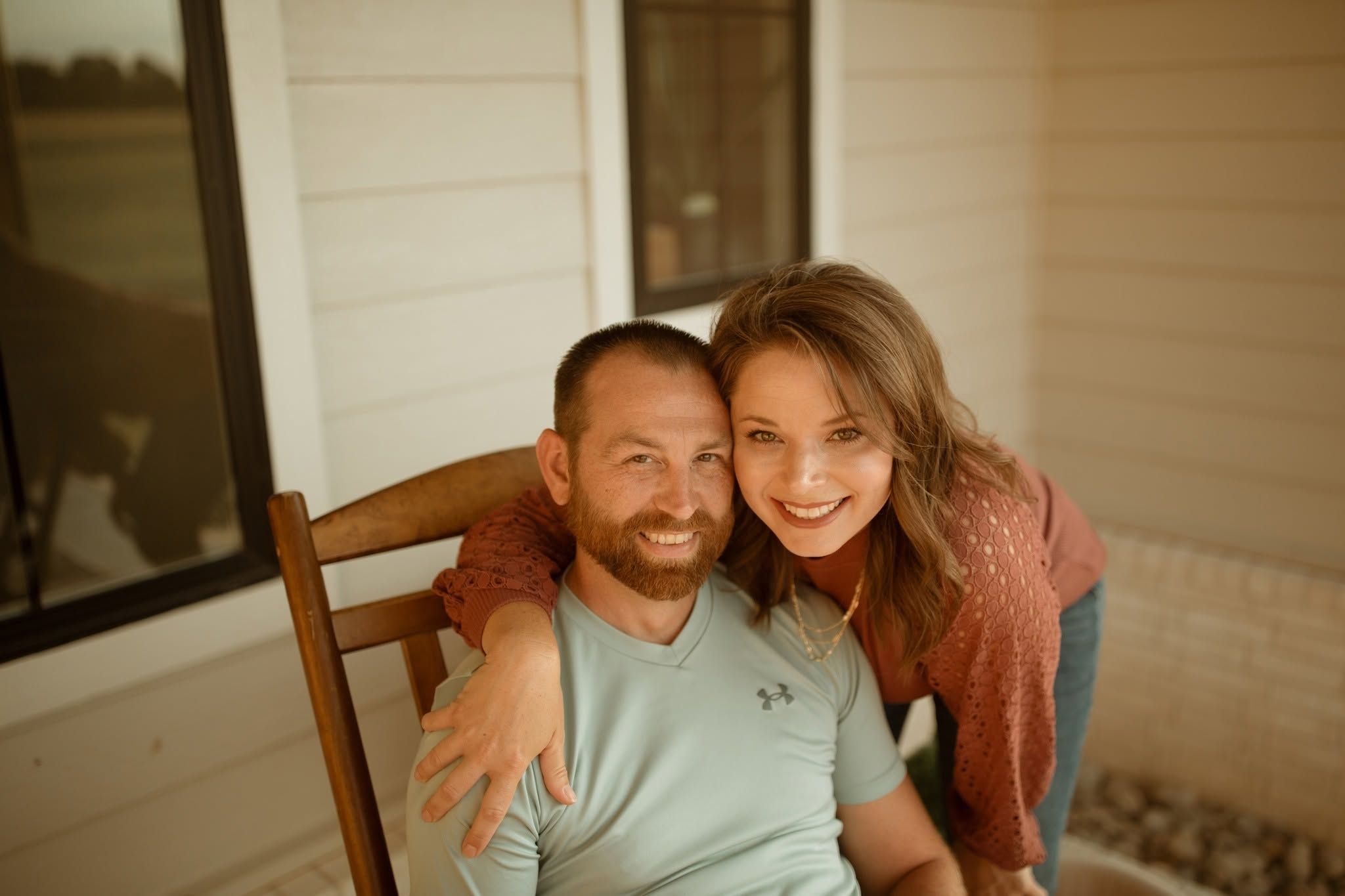 Charity Menefee and Steven seated together on a porch