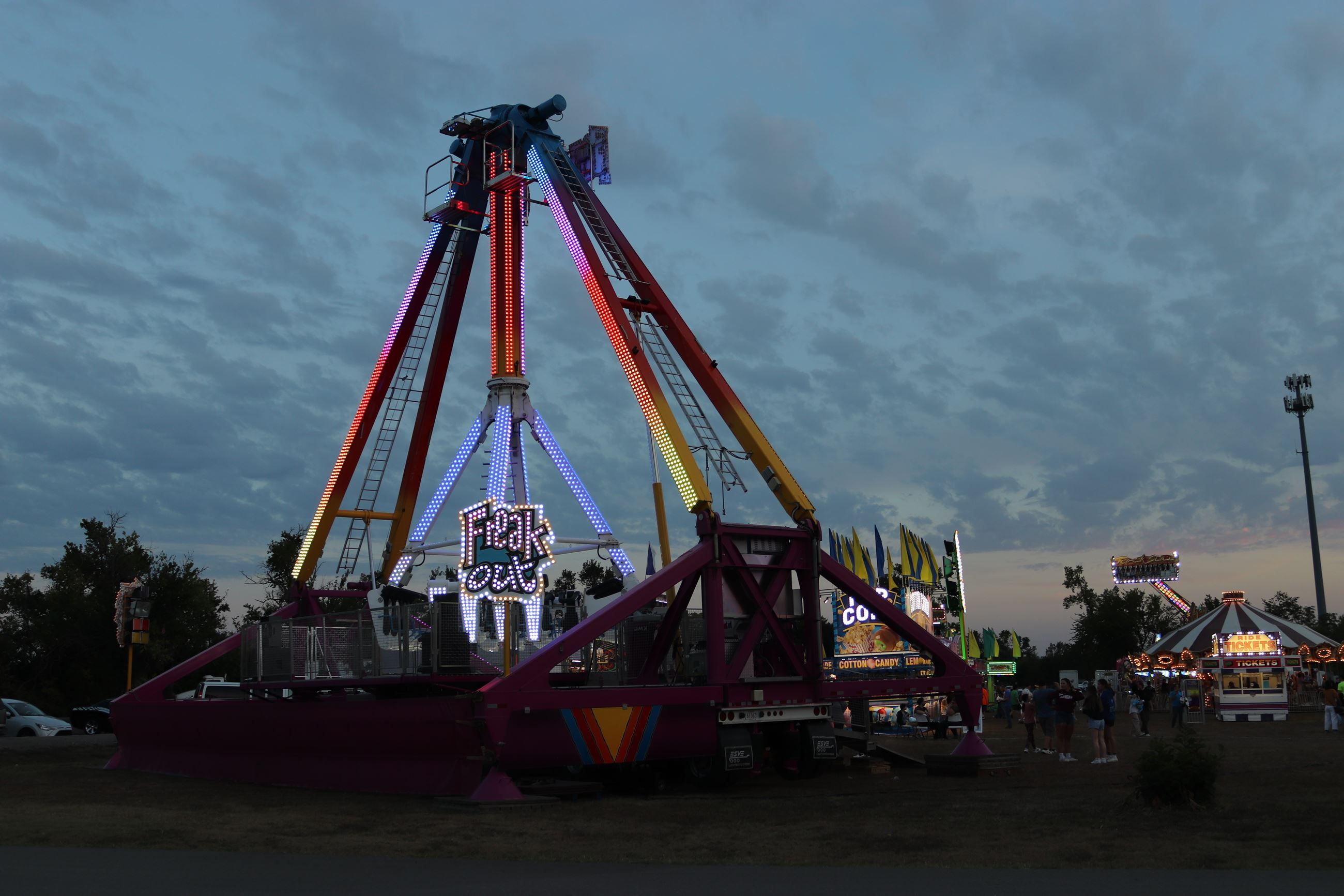 A lit carnival ride and midway at dusk during Greater Andover Days