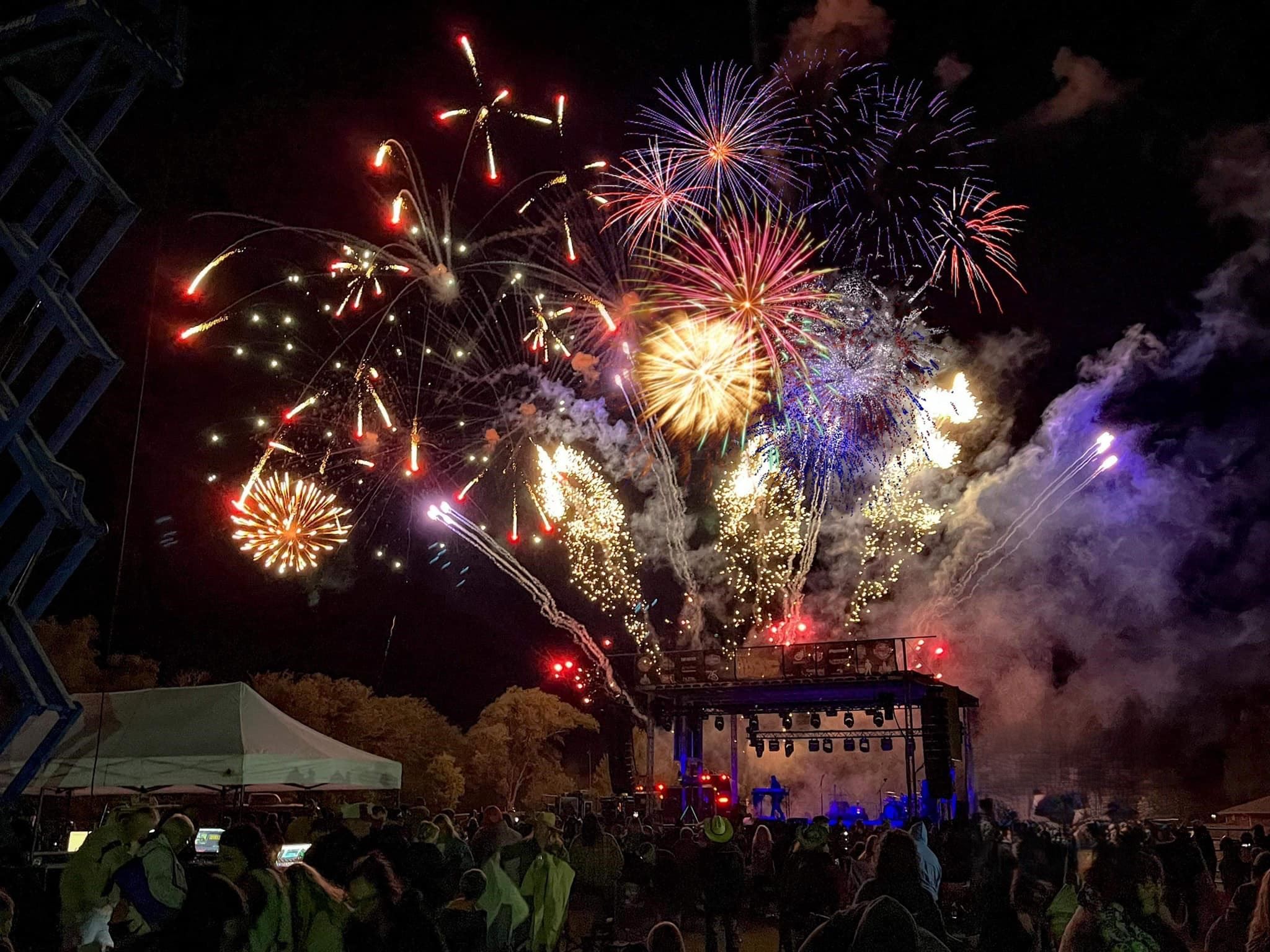 Fireworks bursting above the stage and crowd at the Goddard Fall Festival