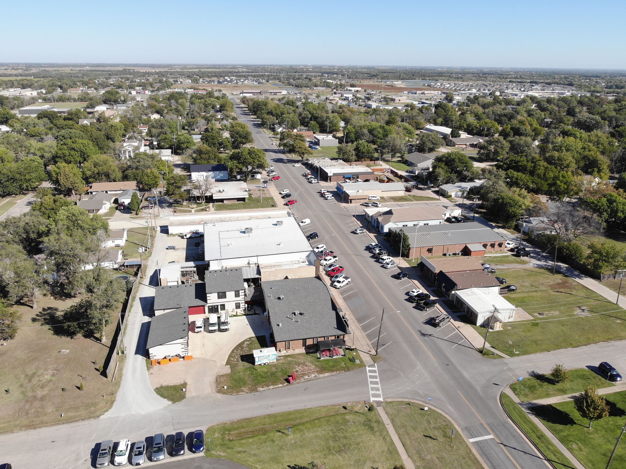An aerial view of Main Street in Goddard, with older storefronts in the foreground and newer rooftops spreading toward the horizon