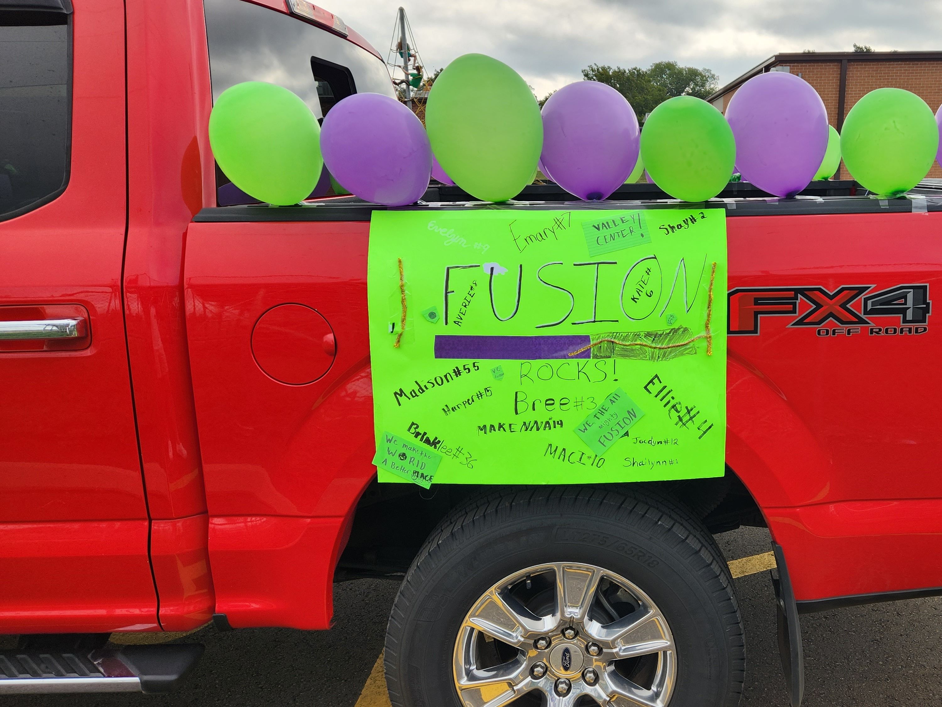 A decorated truck with balloons and a hand-lettered sign waiting in the Valley Center Fall Festival parade lineup