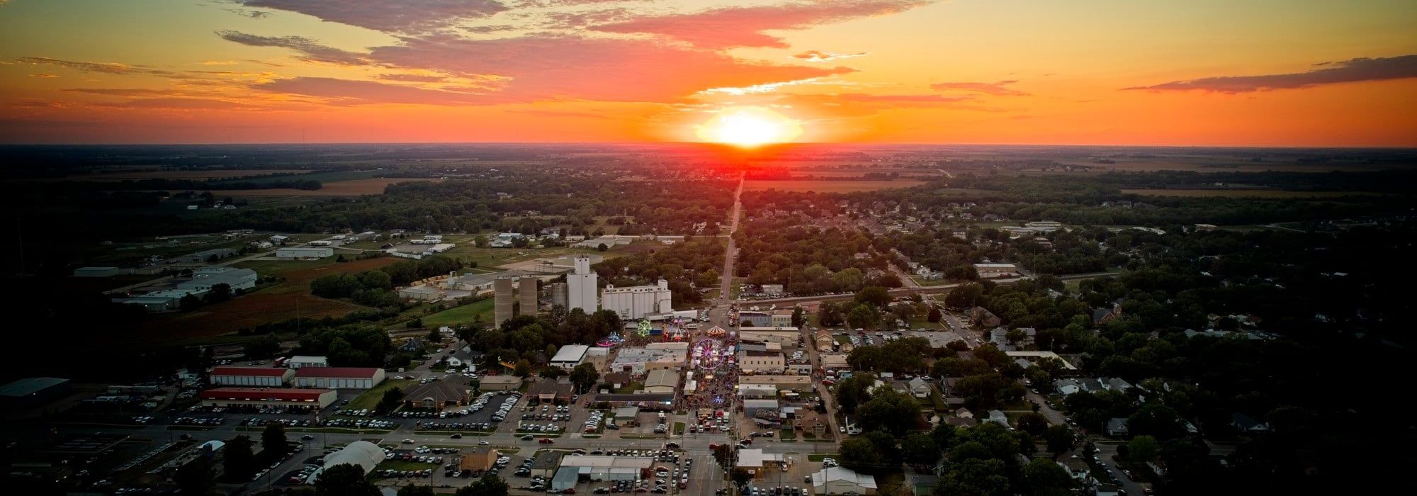 Aerial view of downtown Valley Center at sunset during the Fall Festival, with Main Street leading toward the setting sun