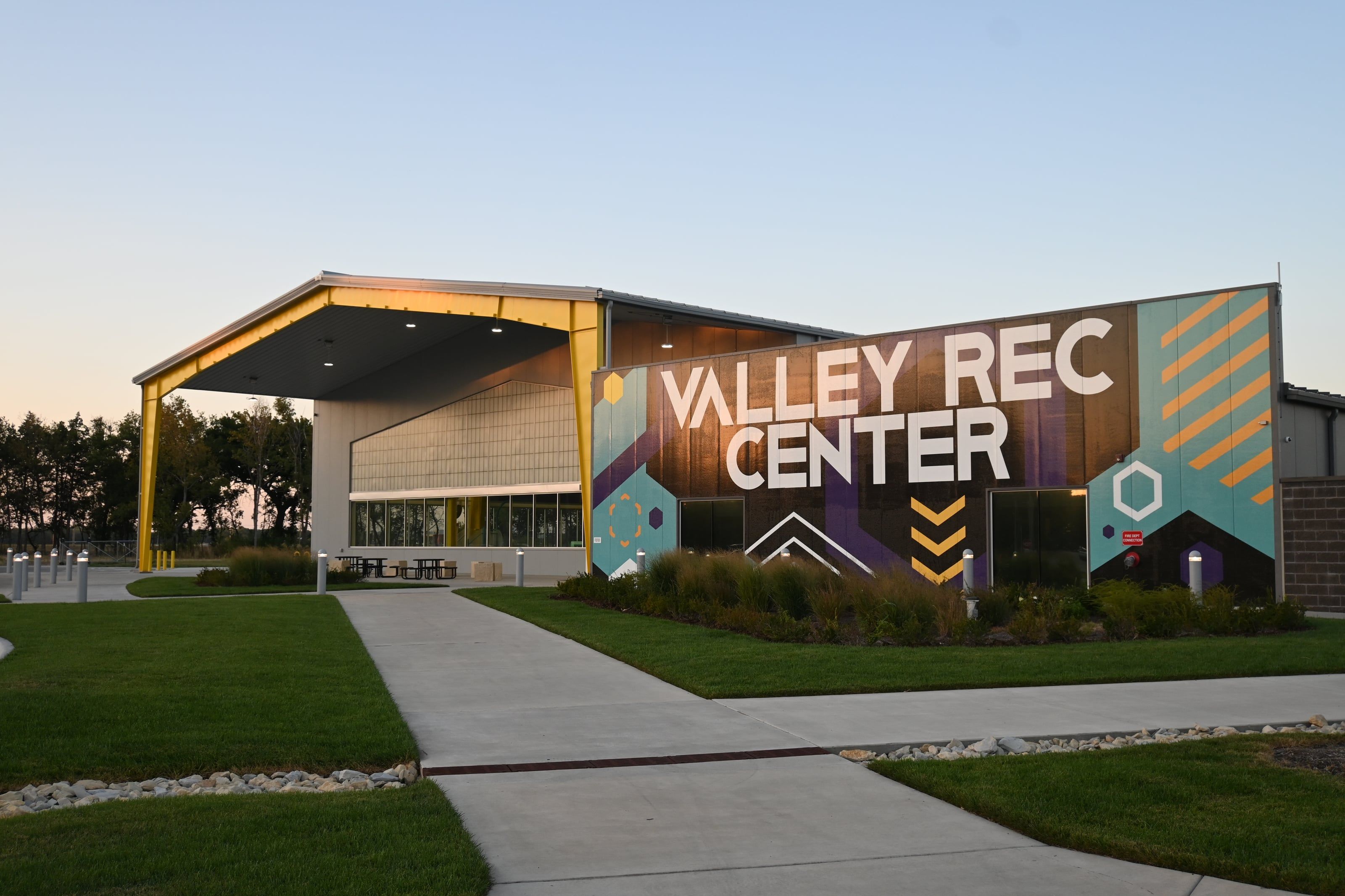 The Valley Rec Center building exterior at dusk, with its covered entrance and mural signage