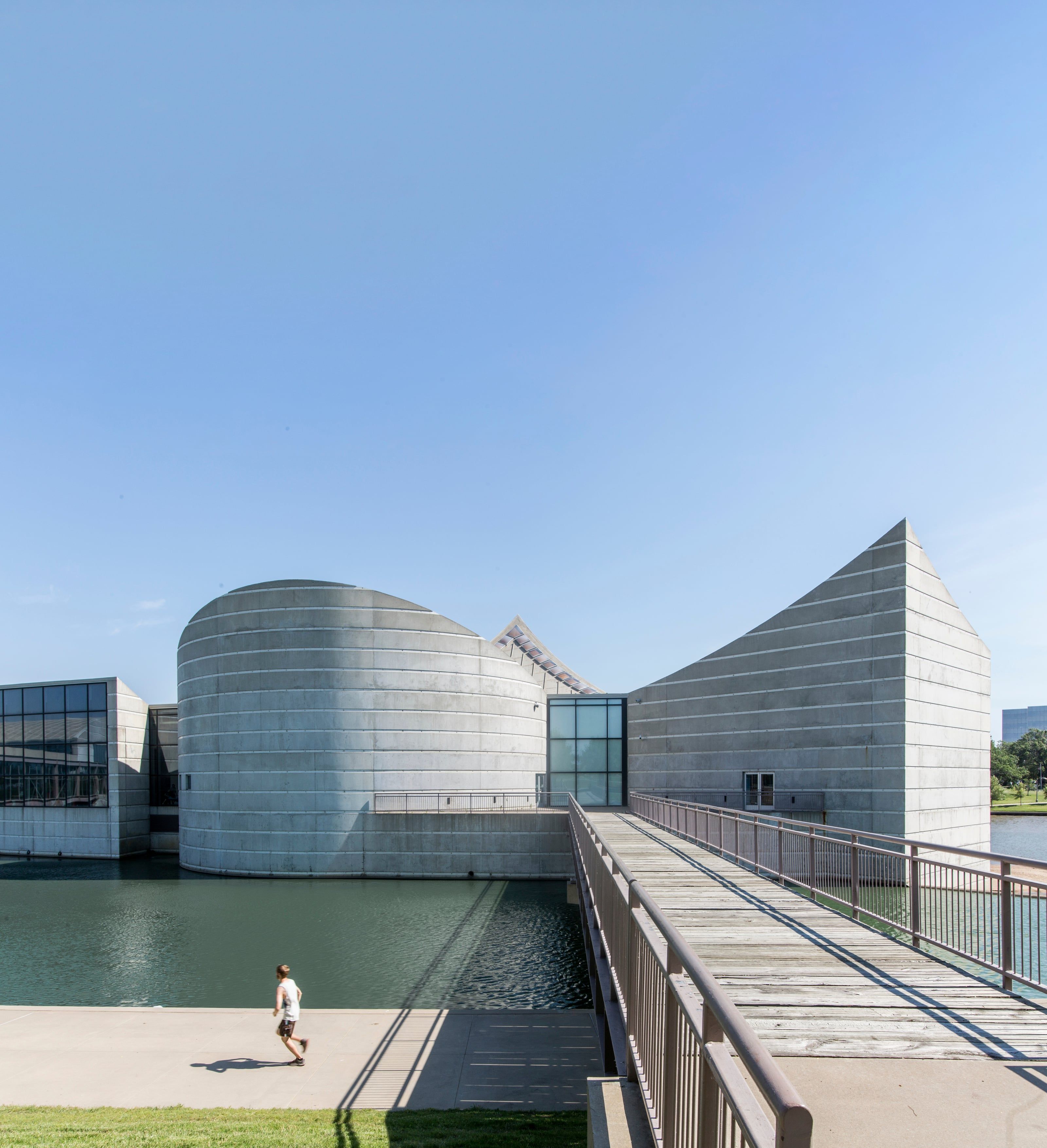 The concrete forms of Exploration Place beside the Arkansas River, with a footbridge leading to the entrance